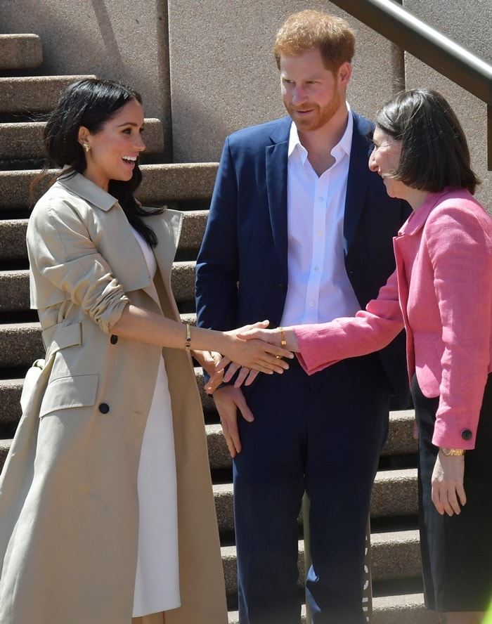 Meghan Markle styled her white dress with a trench coat by Australian designer Martin Grant