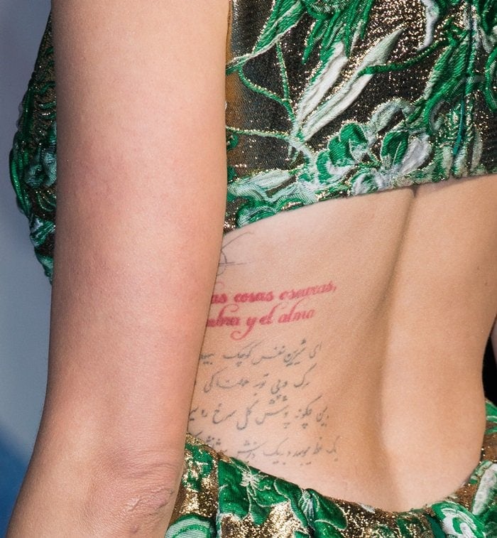 Amber Heard showcases her back tattoos, including a quote in red from Chilean poet Pablo Neruda and Persian script beneath it