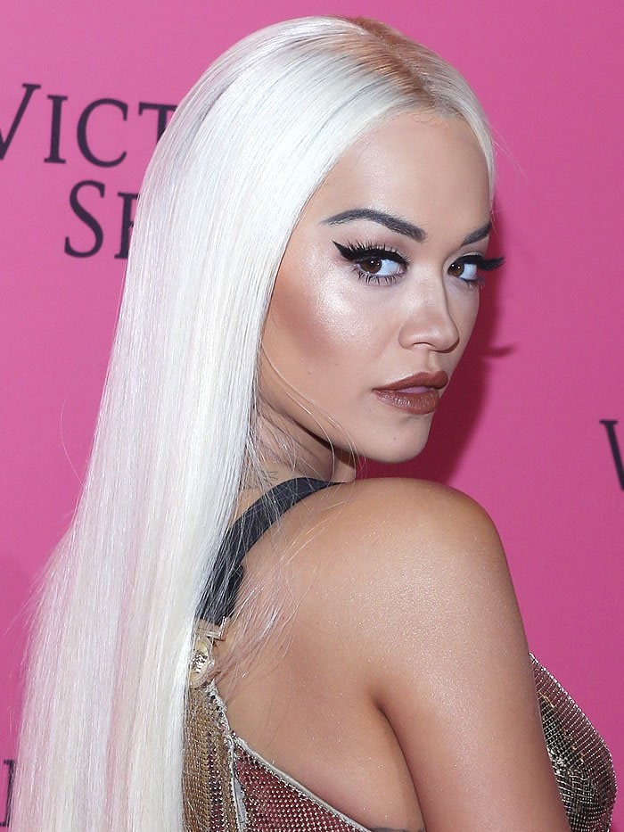 Rita Ora channeling Donatella Versace in a long, straight, platinum-blonde wig