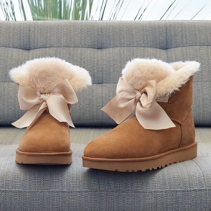 A tonal satin bow adds to the charm of a cozy boot lined and accented with genuine shearling