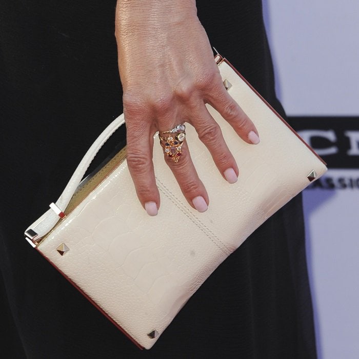 Jennifer Aniston toted a white Valentino clutch and accessorized with Fred Leighton jewelry