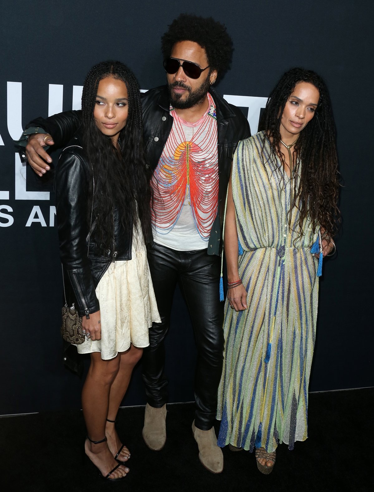 Zoë Kravitz joins her parents Lenny Kravitz and Lisa Bonet on the red carpet, with Zoë in strappy black sandals and a mini dress, Lenny rocking leather pants and suede boots, and Lisa stunning in a flowing striped maxi dress with wedge heels