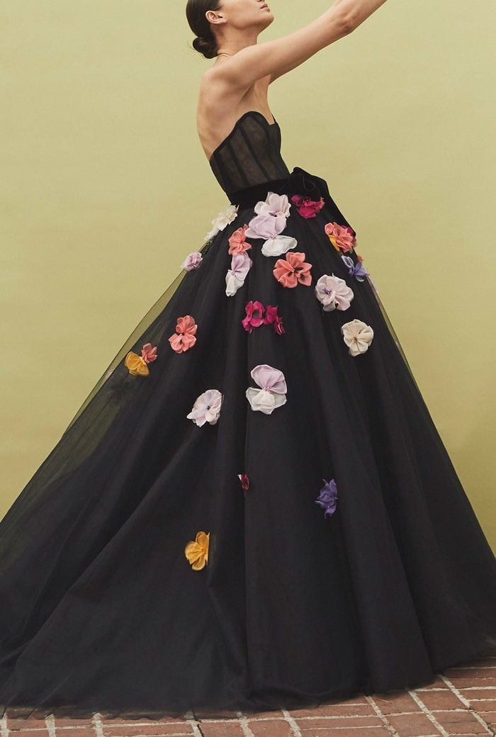 Monique Lhuillier's strapless dress is designed with a plunging sweetheart neckline, an A-line skirt, and 3-dimensional flower embellishments