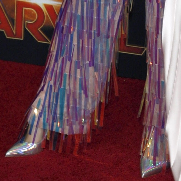 Gemma Chan's iridescent fringed pants paired with luminous Hot Chick pumps by Christian Louboutin at the Captain Marvel premiere