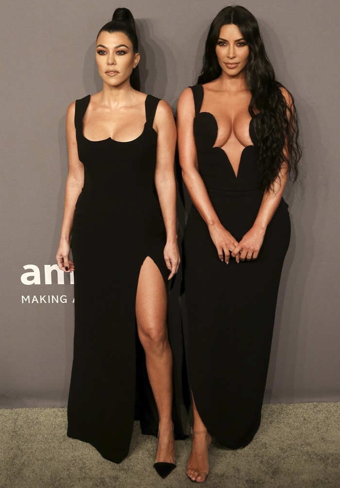 Kourtney and Kim Kardashian bring coordinated Versace glamour to the 2019 amfAR New York Gala at Cipriani Wall Street, turning heads in sleek black gowns with daring silhouettes and sky-high heels