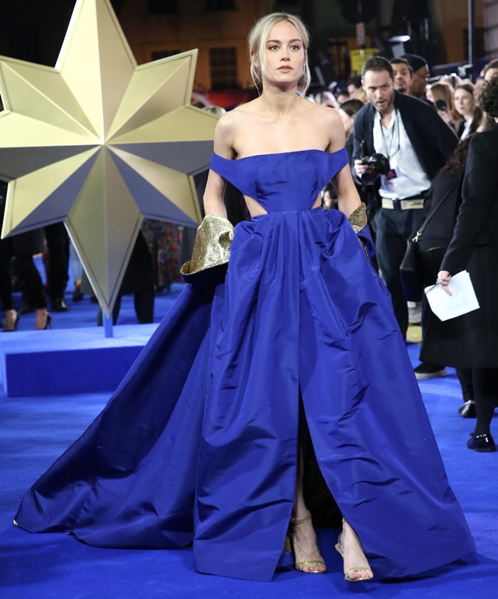 Brie Larson turned heads in a custom cobalt blue Valentino Haute Couture gown with dramatic gold cuffs and matching Christian Louboutin sandals at the Captain Marvel European premiere