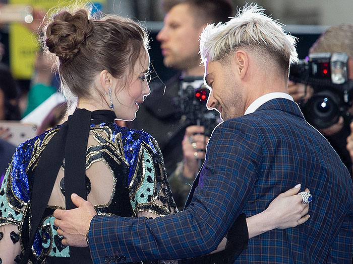 Zac Efron appears captivated by the intricate heart-hand details and shimmering sequins on Lily Collins’ Elie Saab gown