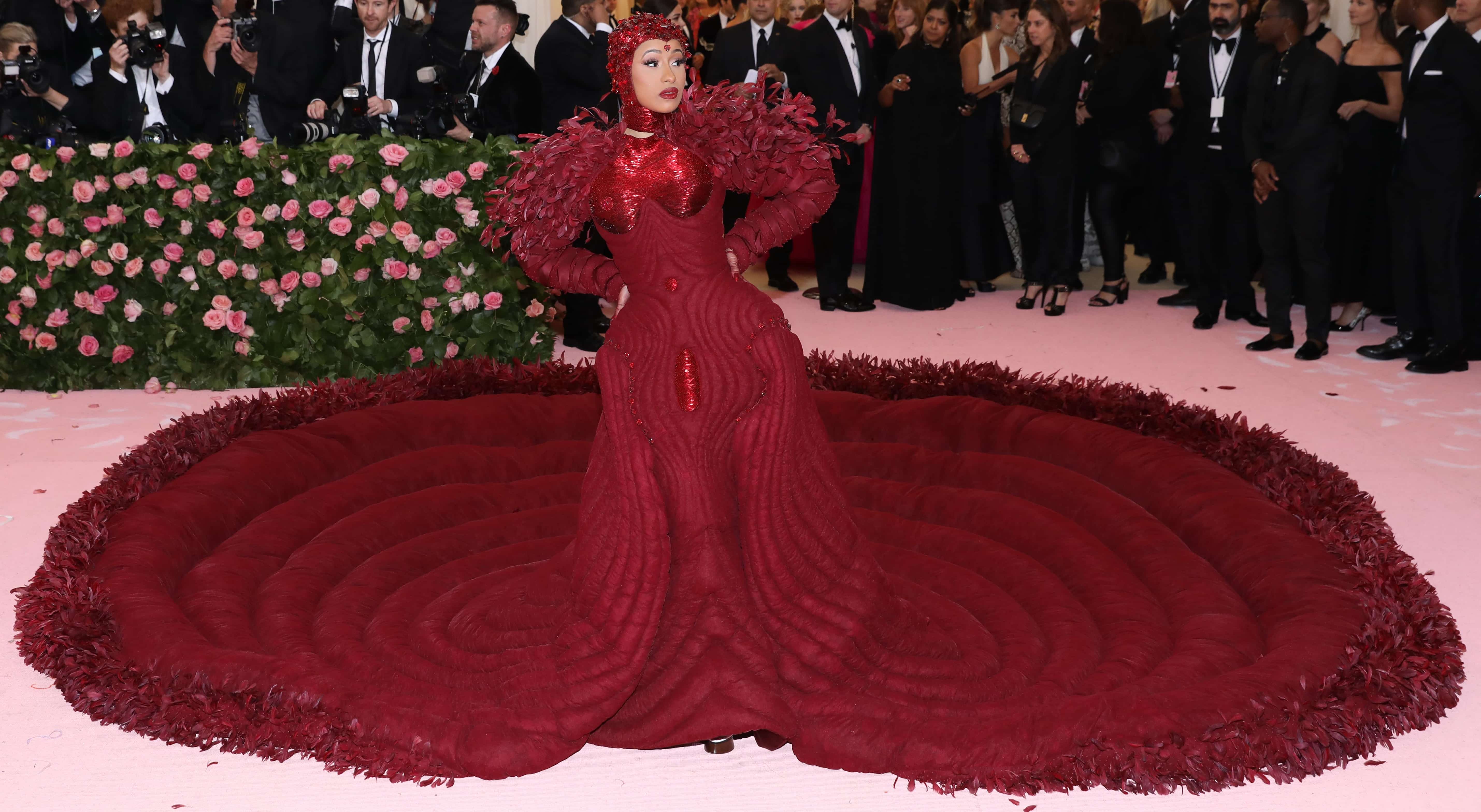 Cardi B’s custom Thom Browne platform brogues barely peek out beneath the enormous feather-trimmed train of her oxblood gown at the 2019 Met Gala