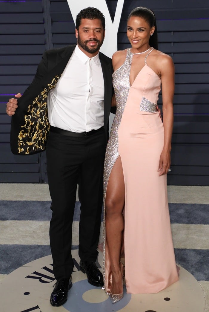 Ciara joins Russell Wilson at the 2019 Vanity Fair Oscar Party in an embellished blush Atelier Versace gown with sparkling metallic pumps