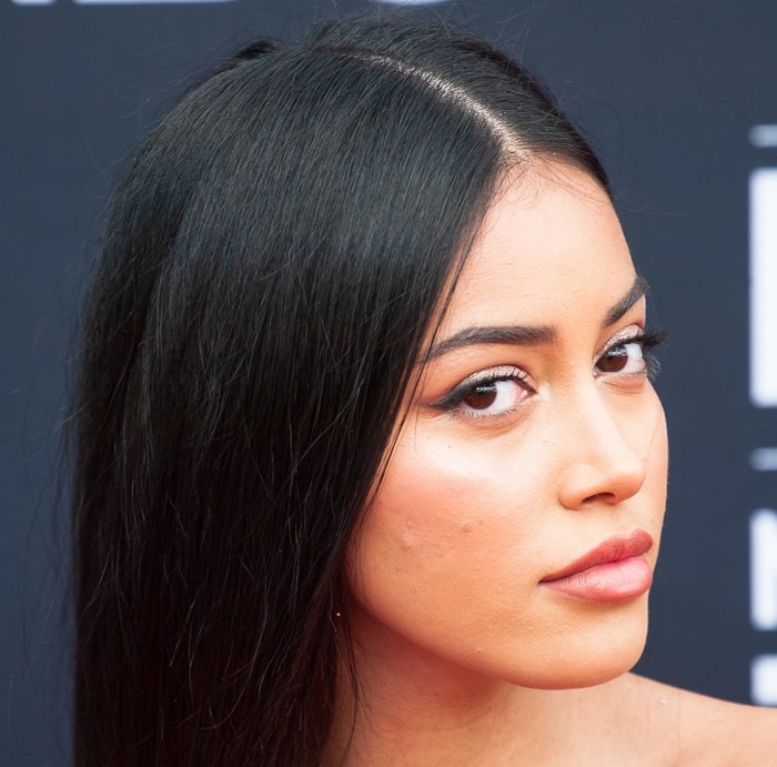 A close-up beauty shot highlights Cindy Kimberly’s sleek, center-parted hair and soft glam makeup, complementing the warm gold tones of her strapless red-carpet look