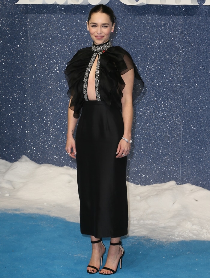 Emilia Clarke sharpens the drama of her crystal-trimmed Prada gown with black Gianvito Rossi “Portofino 70” sandals, the barely-there suede straps and mid-height stiletto elongating her 5'2" frame while keeping the focus on the neckline’s intricate detailing