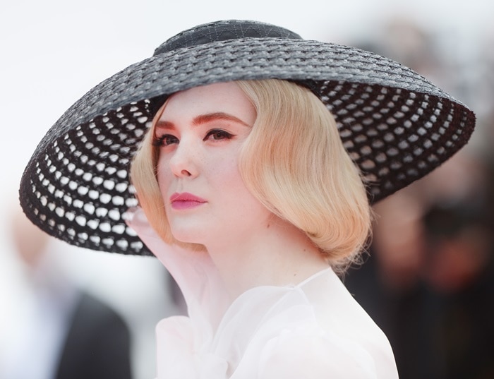 Elle Fanning finished the Dior couture look with a dramatic wide-brim macramé hat, reinforcing the ensemble’s Old Hollywood glamour and Hitchcock-inspired mystique