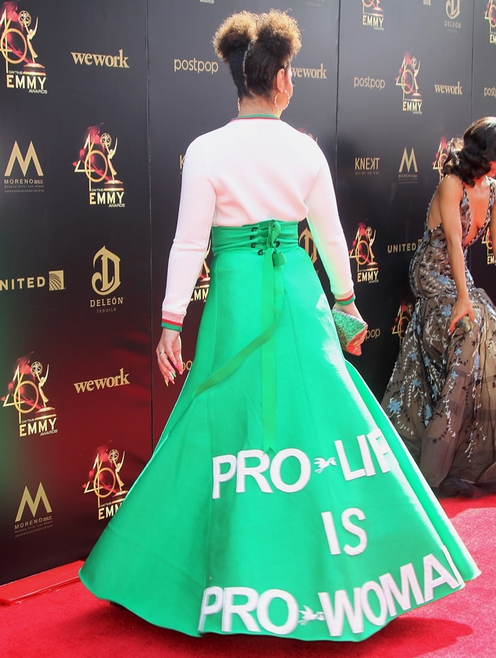 The back of Joy Villa’s voluminous green skirt displayed the phrase “Pro-life is pro-woman,” while her metallic platform heels peeked out beneath the structured hem at the 2019 Daytime Emmy Awards