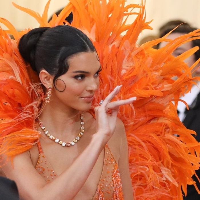 Kendall Jenner completed her showstopping Met Gala look with slicked-back hair, soft face-framing curls, and sparkling Tiffany Co. jewelry, including drop earrings and a diamond necklace
