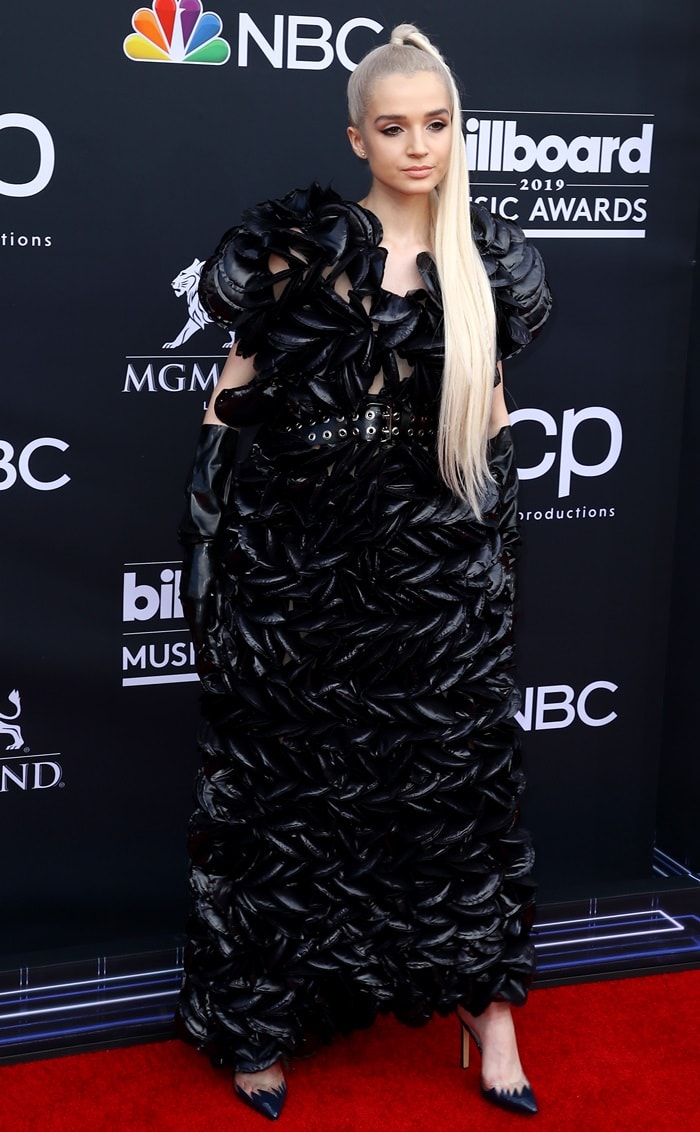 Poppy arrives at the 2019 Billboard Music Awards in Las Vegas wearing a sculptural Moncler 6 Noir Kei Ninomiya dress inspired by mussel shells, paired with pointed-toe Loriblu pumps and glossy black opera gloves