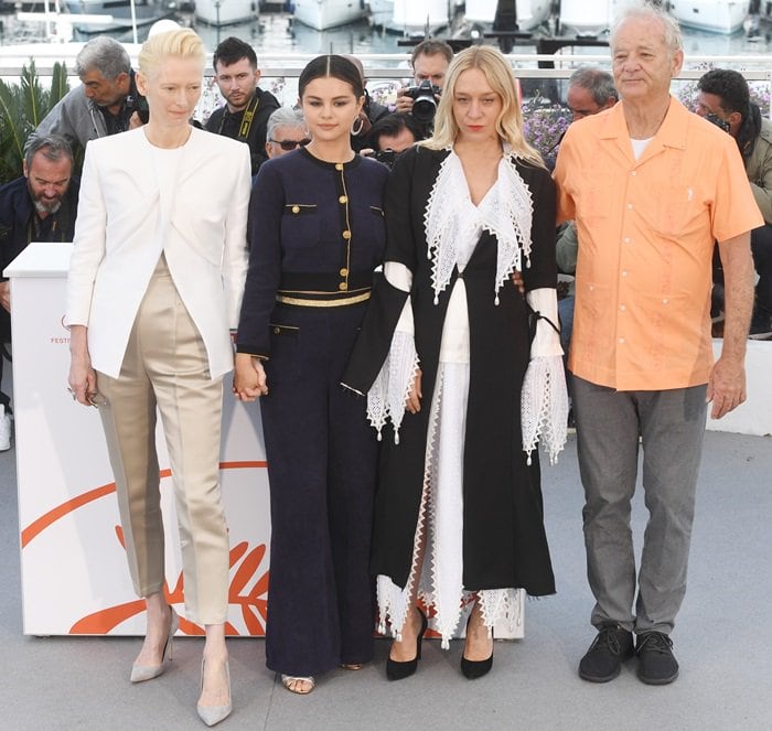 Tilda Swinton, Selena Gomez, and Chloë Sevigny showcased three distinct approaches to Cannes photocall dressing—Swinton in pointed-toe pumps, Gomez in concealed Tabitha Simmons Toni sandals beneath a Chanel Cruise 2019 jumpsuit, and Sevigny in classic black pumps—while Bill Murray kept things relaxed in an apricot short-sleeve shirt