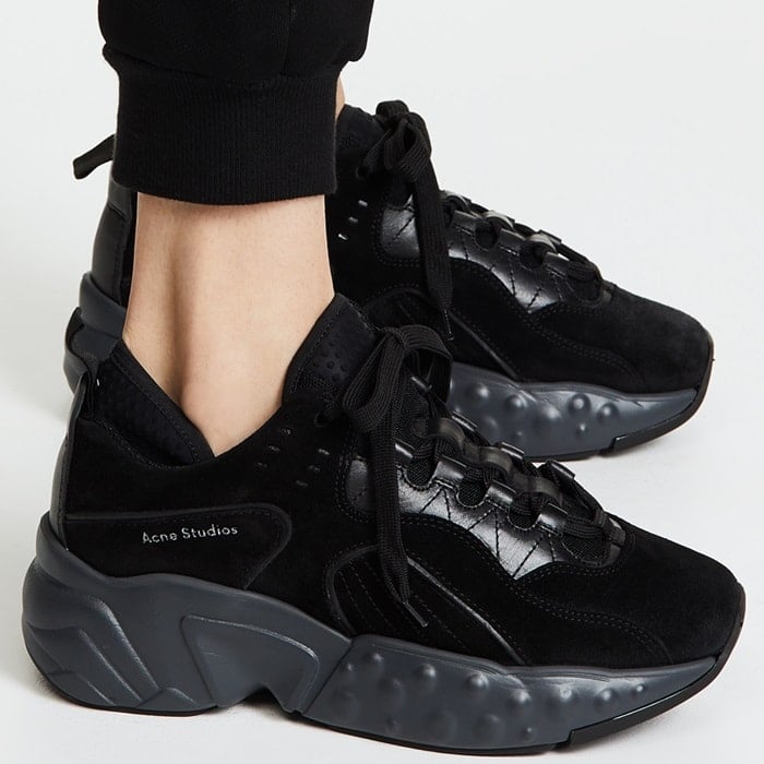 Acne Studios’ black Manhattan sneakers fuse plush suede uppers with a sculptural rubber sole, delivering a bold, street-inspired silhouette with luxury edge