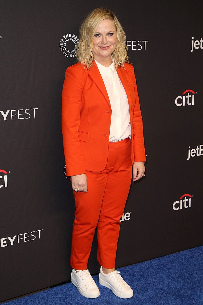 Amy Poehler stuns in a bold orange pantsuit paired with crisp white sneakers at the PaleyFest LA