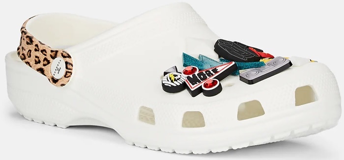 The white Barneys New York XO Crocs clog gets a playful punk twist with a leopard-print heel strap and ’80s-inspired Jibbitz charms
