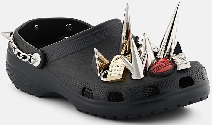 The black XO Crocs clog features towering chrome spikes and gold-toned charms that turn the classic silhouette into a statement piece