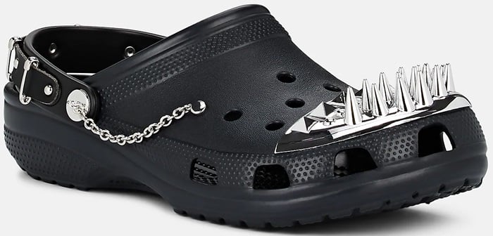 This black clog is reimagined with a silver chain backstrap and a spiked metal toe plate for a sleek, attitude-heavy finish