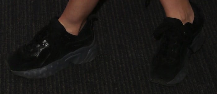 Ella Eyre grounds her vibrant Summertime Ball look with black Acne Studios “Manhattan” suede sneakers, adding a chunky, street-style edge to the pink ensemble.