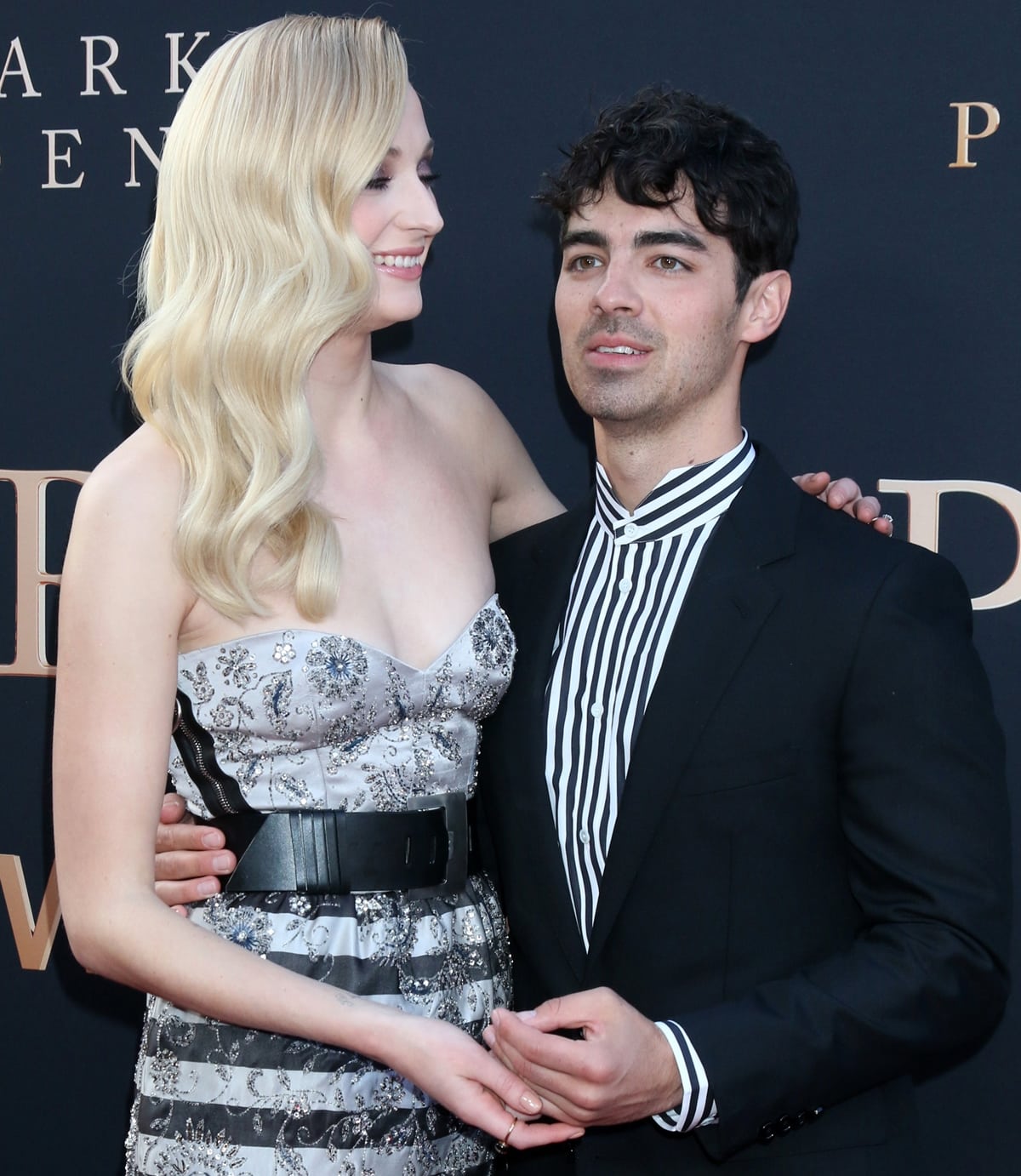 Sophie Turner styles her long blonde hair in soft Hollywood waves, perfectly complementing her strapless embellished gown at the Dark Phoenix premiere with Joe Jonas
