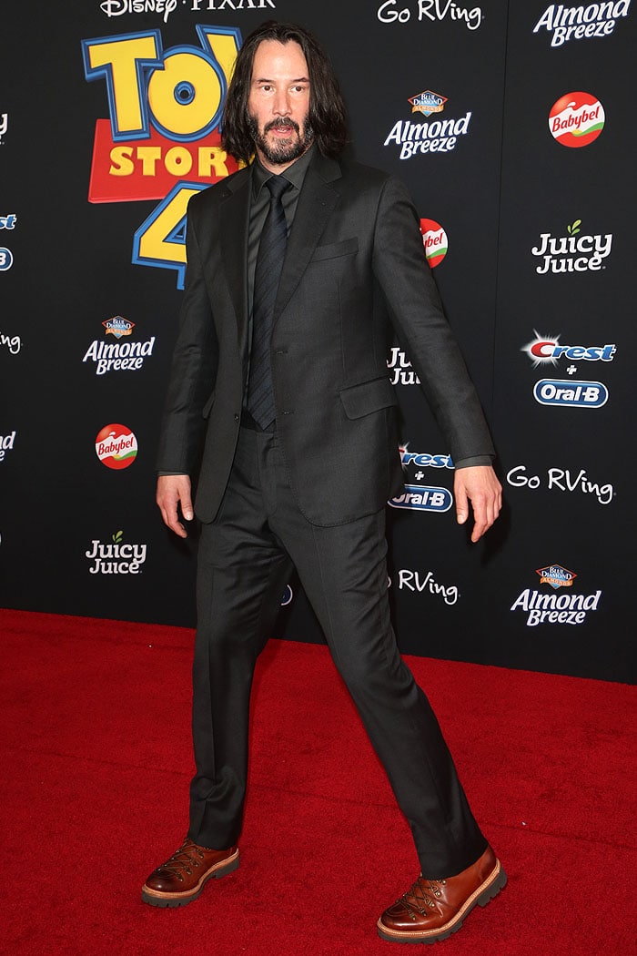 Keanu Reeves brings rugged charm to the Toy Story 4 premiere in a sharp black suit paired with standout brown boots