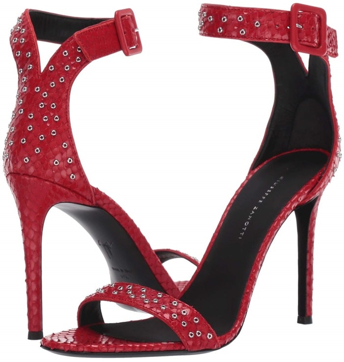 Giuseppe Zanotti's $995 snake-embossed stiletto sandals feature metallic eyelets across the toe strap, ankle strap, and heel, finished with a tonal covered buckle