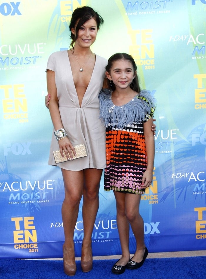 Rowan Blanchard, then 9, wears embellished black ballet flats with a colorful patterned dress alongside her mother, Elizabeth Blanchard, at the 2011 Teen Choice Awards in Universal City, California