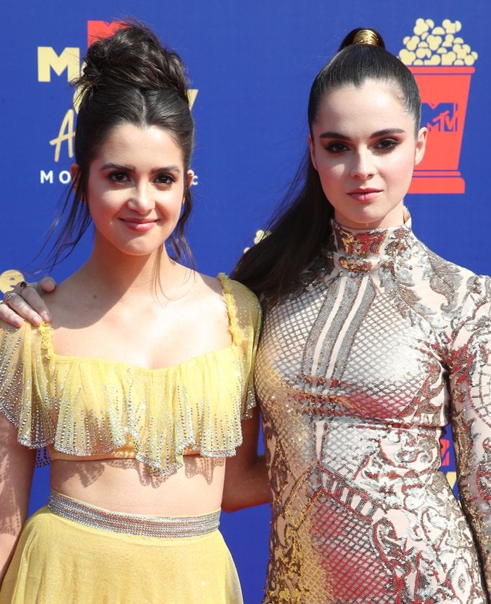 Laura Marano’s crystal-fringed Raisa Vanessa crop top and Hearts On Fire jewelry complement Vanessa Marano’s intricately embellished gold Kimberly Parker mini dress