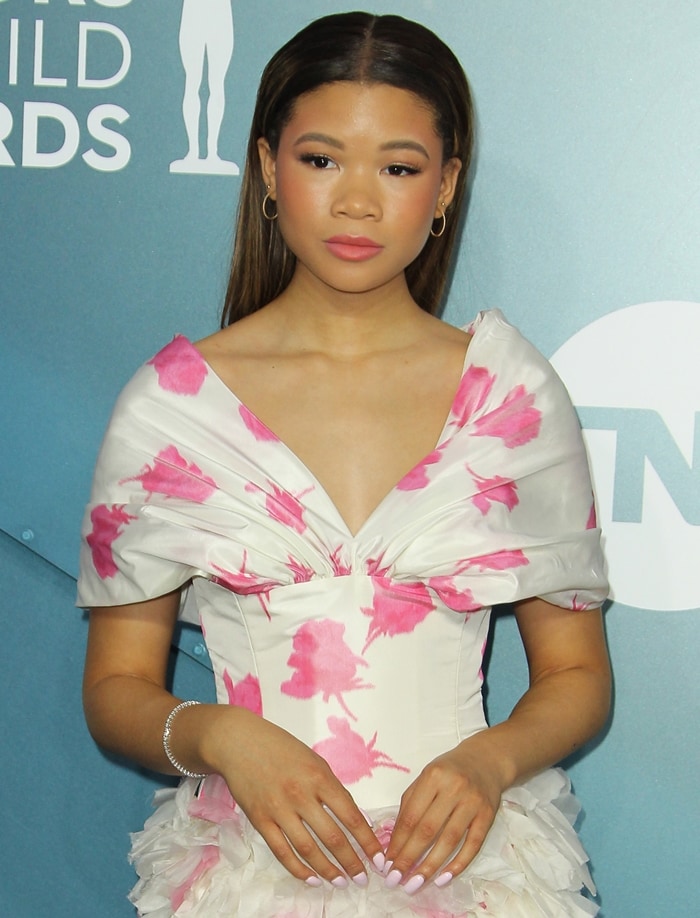 The off-the-shoulder Giambattista Valli design featured painterly pink floral motifs, a structured bodice, and dramatic folded sleeves that framed Storm Reid's understated beauty look