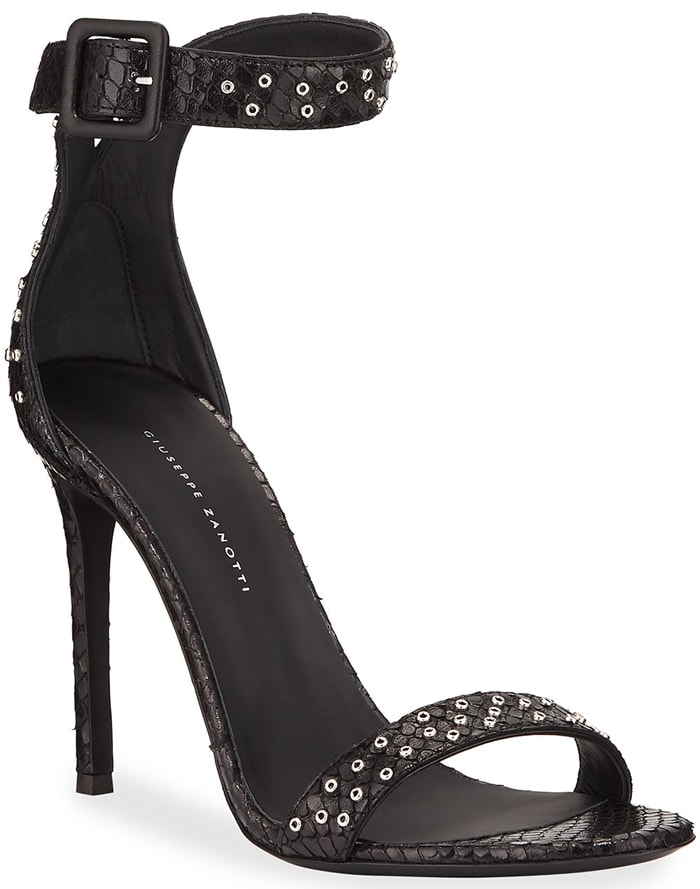 The black version of Giuseppe Zanotti's snake-embossed ankle-strap sandals highlights the metallic eyelet detailing, covered buckle, and slender stiletto heel