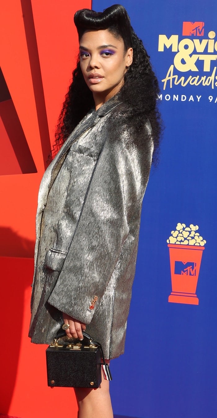 Tessa Thompson carrying a structured black Thom Browne box bag with her metallic silver blazer