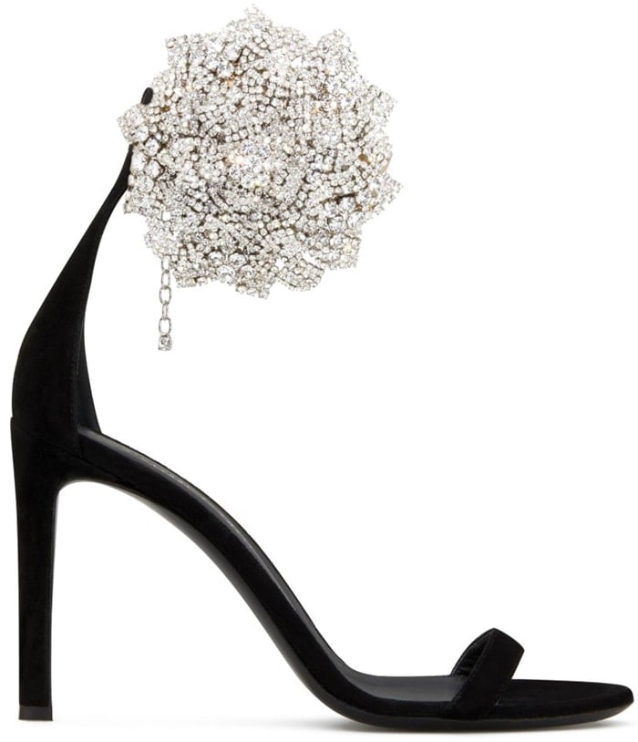 Giuseppe Zanotti’s black Fleur sandal strips the silhouette back to a sleek stiletto and single strap, offset by a dramatic crystal flower at the heel