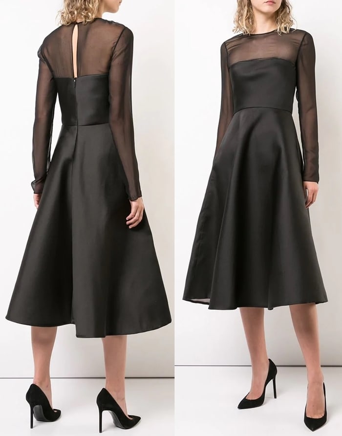 Jason Wu’s black midi dress features a fitted satin bodice, sheer long sleeves, and a flared A-line skirt, shown with classic black pointed-toe pumps