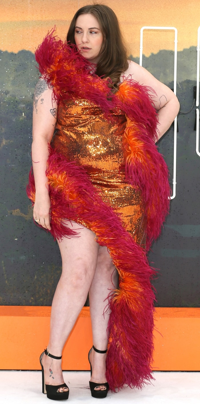 Lena Dunham embraced full-throttle red-carpet glamour in a custom 16ARLINGTON sequined gown trimmed with vivid marabou feathers and grounded by towering Jimmy Choo Liberty platform sandals