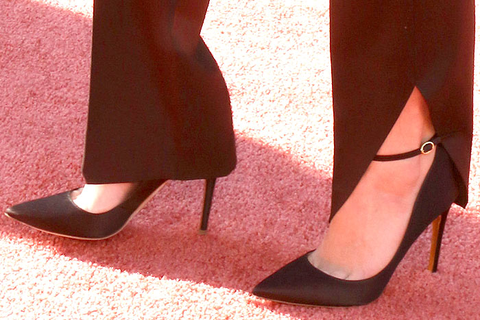 Maya Hawke wearing black satin Rupert Sanderson Balance pointed-toe ankle-strap pumps