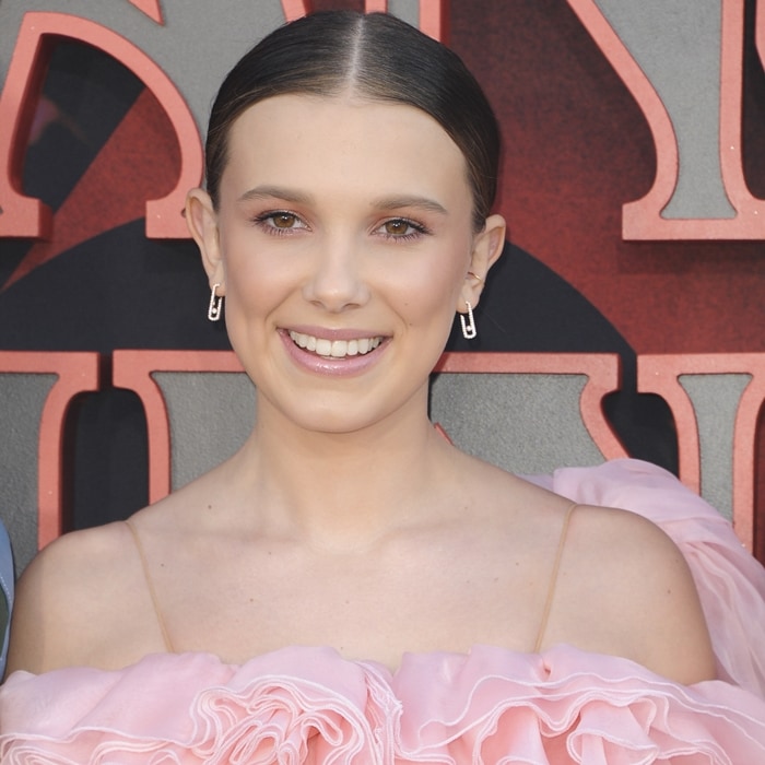 Millie Bobby Brown flashes her fixed teeth and her Move Addiction earrings in 18-carat white gold