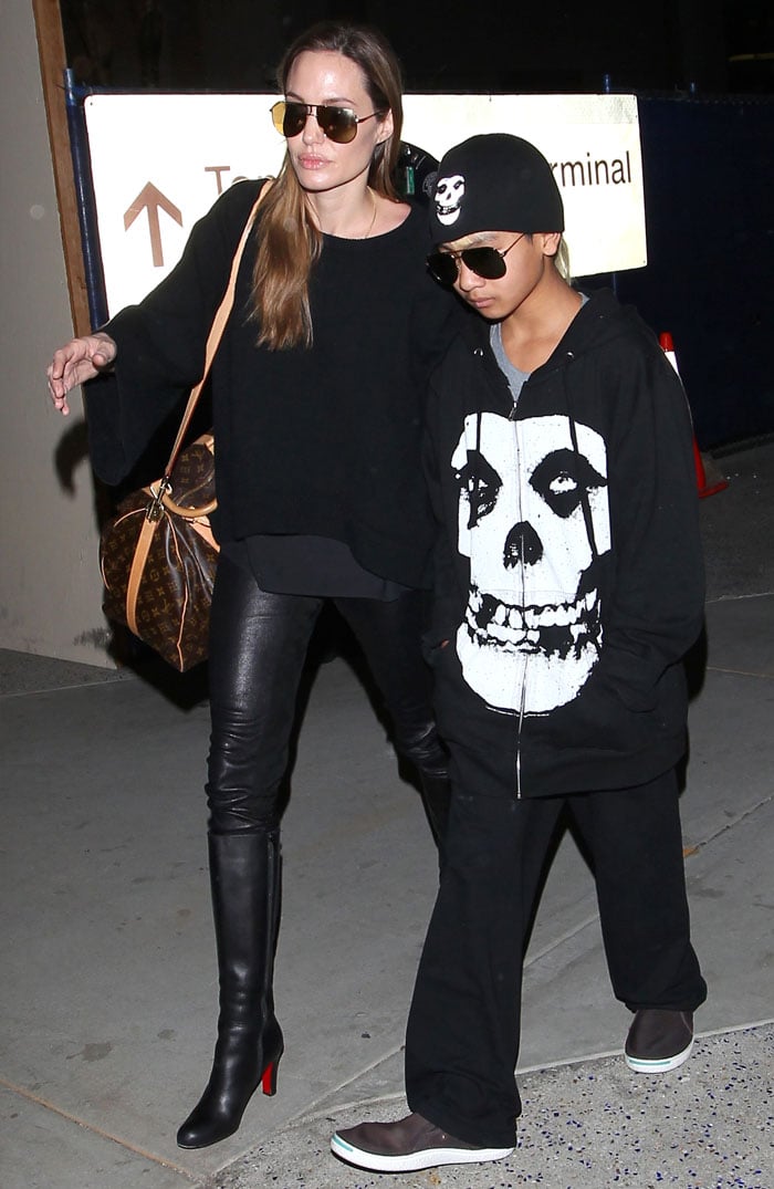 Angelina Jolie and Maddox nail edgy airport style in matching all-black outfits, with Angelina turning heads in leather leggings and iconic Christian Louboutin knee-high boots at LAX on April 13, 2013