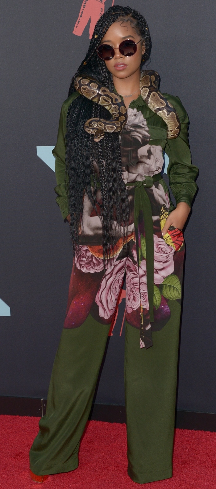 Wearing a floral Valentino jumpsuit cinched at the waist, H.E.R. balanced the relaxed wide-leg silhouette with towering gold metallic Giuseppe Zanotti platform heels at the Prudential Center in Newark, New Jersey