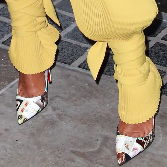 Jada Pinkett Smith’s sharp pointed-toe Christian Louboutin “So Kate” pumps are crafted in glossy, multi-colored collage-printed patent leather, finished with the house’s signature red lacquered soles and a vertiginous 120mm stiletto