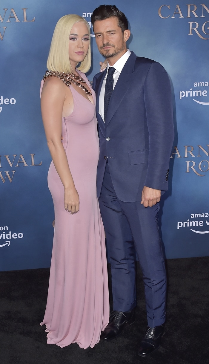 Katy Perry wears a blush-pink Tom Ford Fall 2019 gown with sculptural chain-link straps alongside Orlando Bloom in a navy Tom Ford suit at the Carnival Row premiere