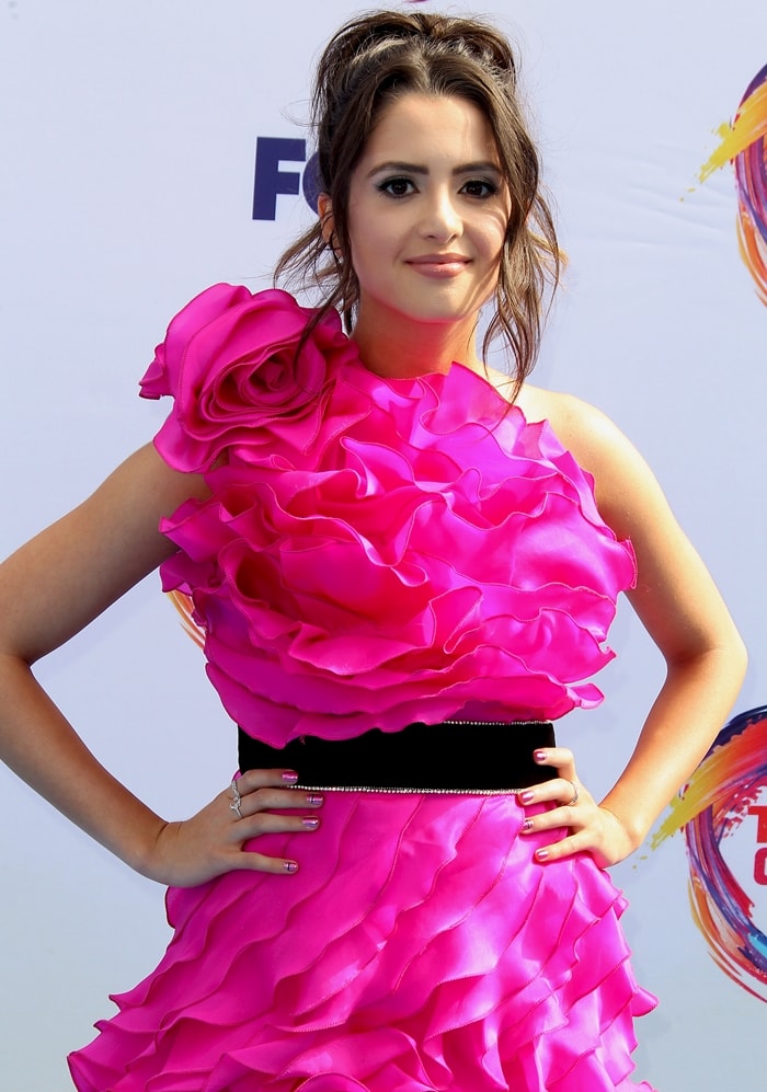 Laura Marano shows the oversized ruffles and black waist belt of her pink Raisa Vanessa Teen Choice Awards dress