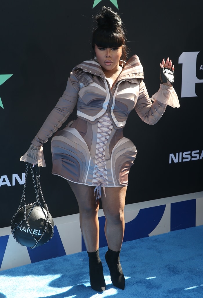 Lil' Kim showcases futuristic flair at the 2019 BET Awards in a sculpted mini dress paired with black sock booties and a basketball-inspired Chanel purse