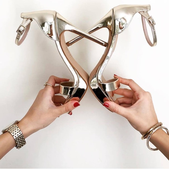 Metallic rose-gold Aldo Madalene ankle-strap sandals feature slender straps and a mirror-like finish that create an elegant, leg-lengthening effect