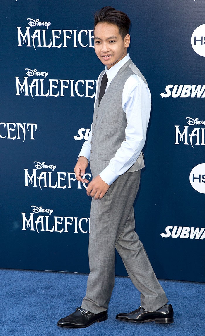 Maddox Chivan Jolie-Pitt makes a confident solo appearance in a sharp gray suit and classic black horsebit loafers at the Maleficent world premiere at El Capitan Theatre in Hollywood on May 28, 2014