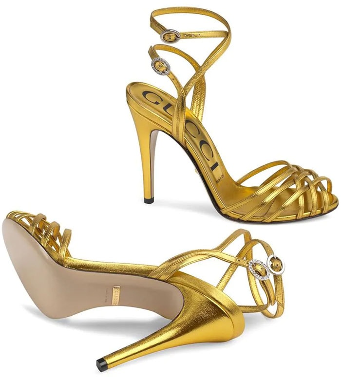 Gucci gold metallic crisscross-strap sandals featuring slender ankle straps and a sleek stiletto heel, priced at $890