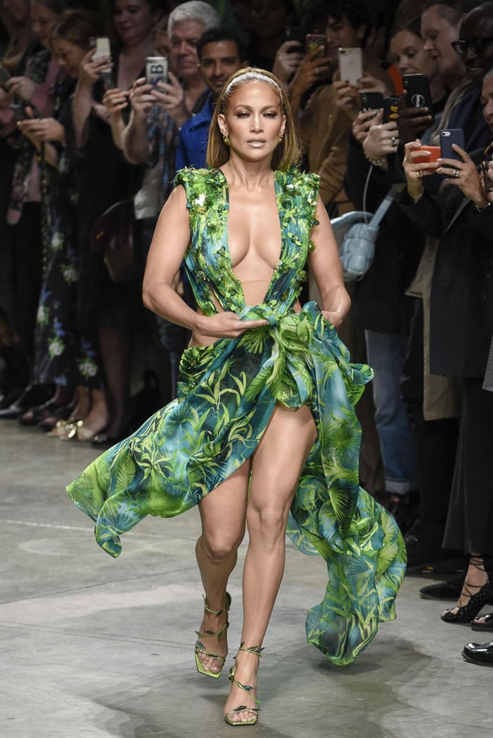 Jennifer Lopez closes the Versace Spring 2020 runway in Milan wearing a reimagined version of her iconic jungle-print Grammy dress, paired with custom green snakeskin-effect sandals featuring square toes and delicate leaf-wrapped straps