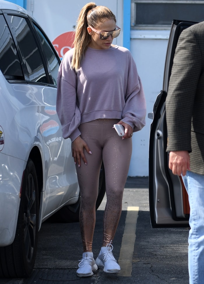 Jennifer Lopez keeps it sporty-chic in rose-gold ombré Beyond Yoga leggings and crisp white Nike Air Presto sneakers while out in Miami on May 29, 2019